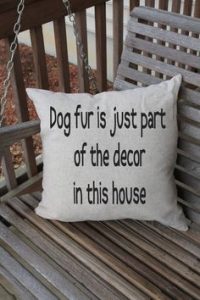 Image of a throw pillow with the words "Dog fur is just part of the decor in this house."