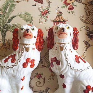 A pair of pottery Staffordshire dogs based on the Cavalier King Charles Spaniel breed.